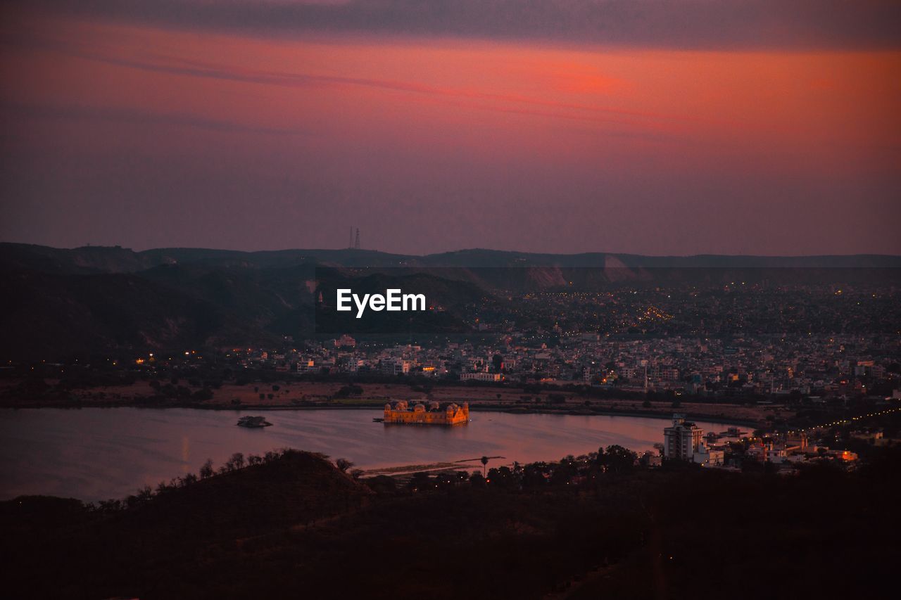 High angle view of illuminated city against sky during sunset