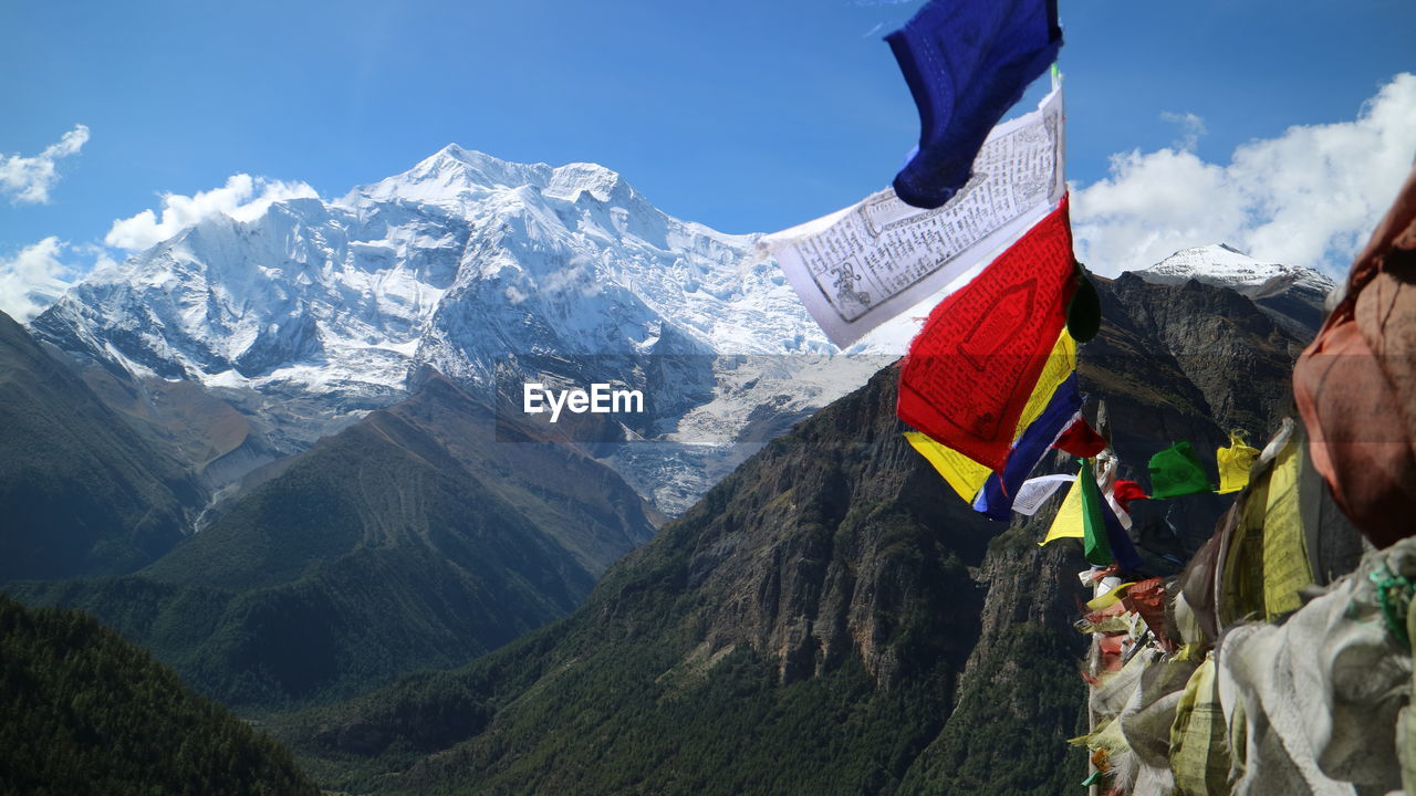 Panoramic view of mountains and flags against sky