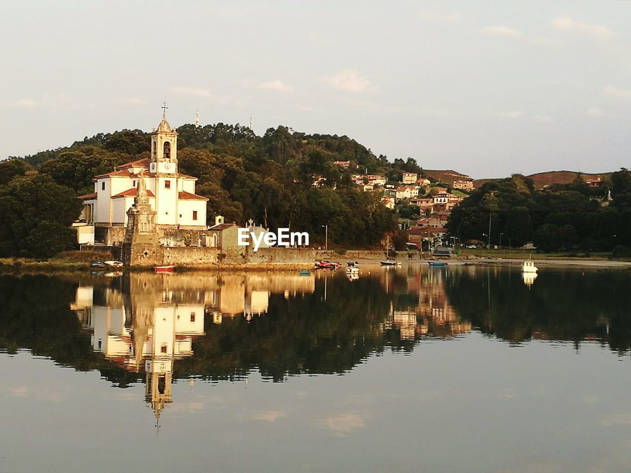 Reflection of church on lake against clear sky
