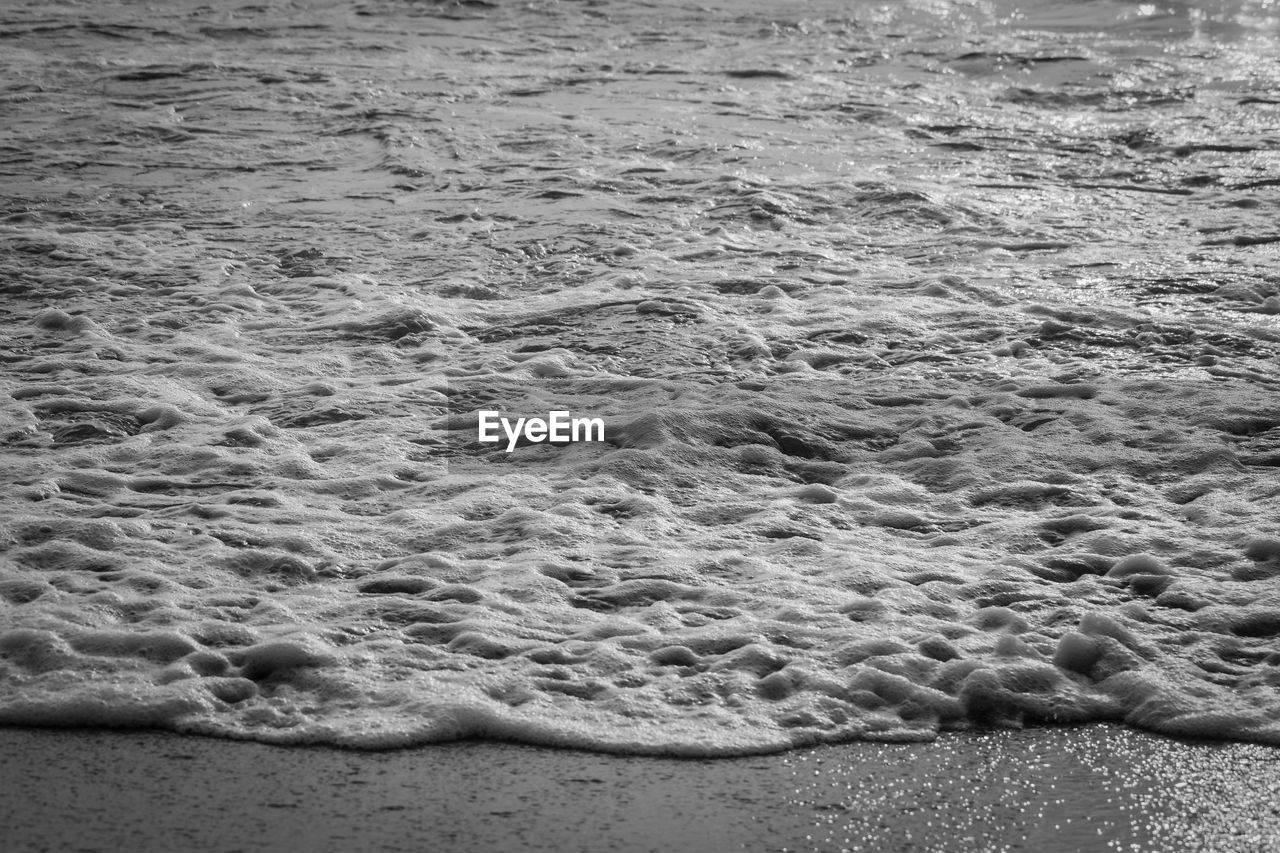 land, beach, water, sand, sea, black and white, wave, nature, day, monochrome, shore, monochrome photography, no people, high angle view, beauty in nature, rock, tranquility, ocean, motion, coast, outdoors, wind wave, water sports, sports, pattern, white, full frame, scenics - nature, sunlight, backgrounds, tranquil scene
