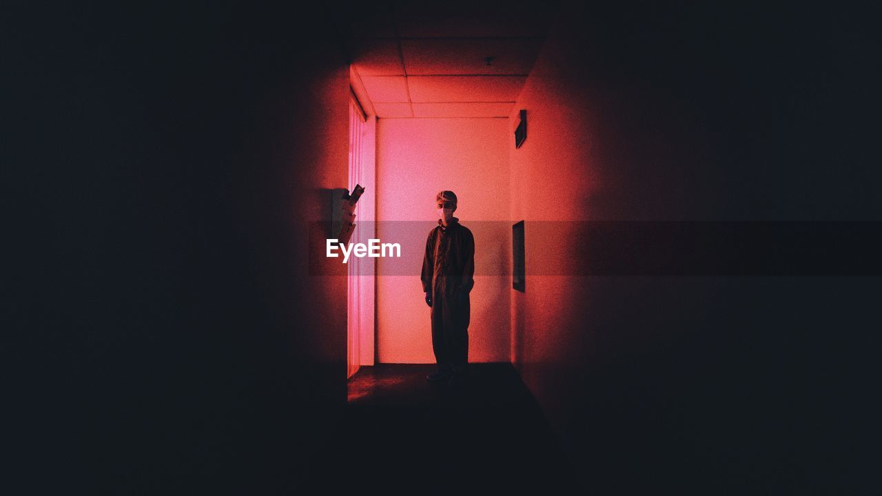 Young man standing in darkroom