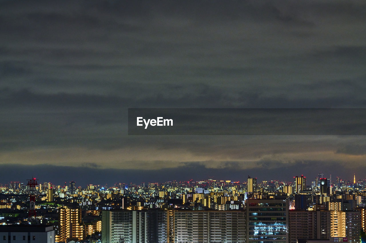 ILLUMINATED BUILDINGS IN CITY AGAINST SKY