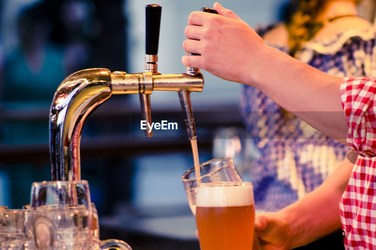 Close-up of hand pouring drink in glass