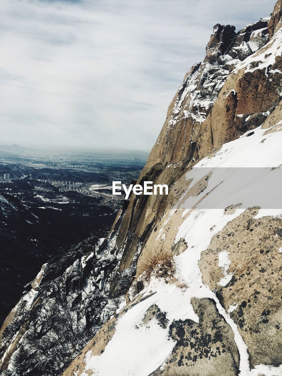 Aerial view of snowcapped mountain by sea against sky