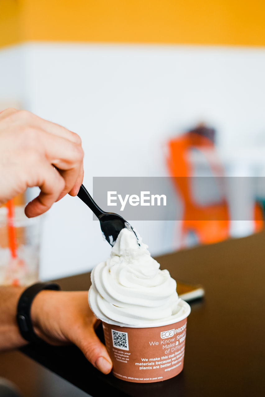 CLOSE-UP OF HANDS HOLDING ICE CREAM