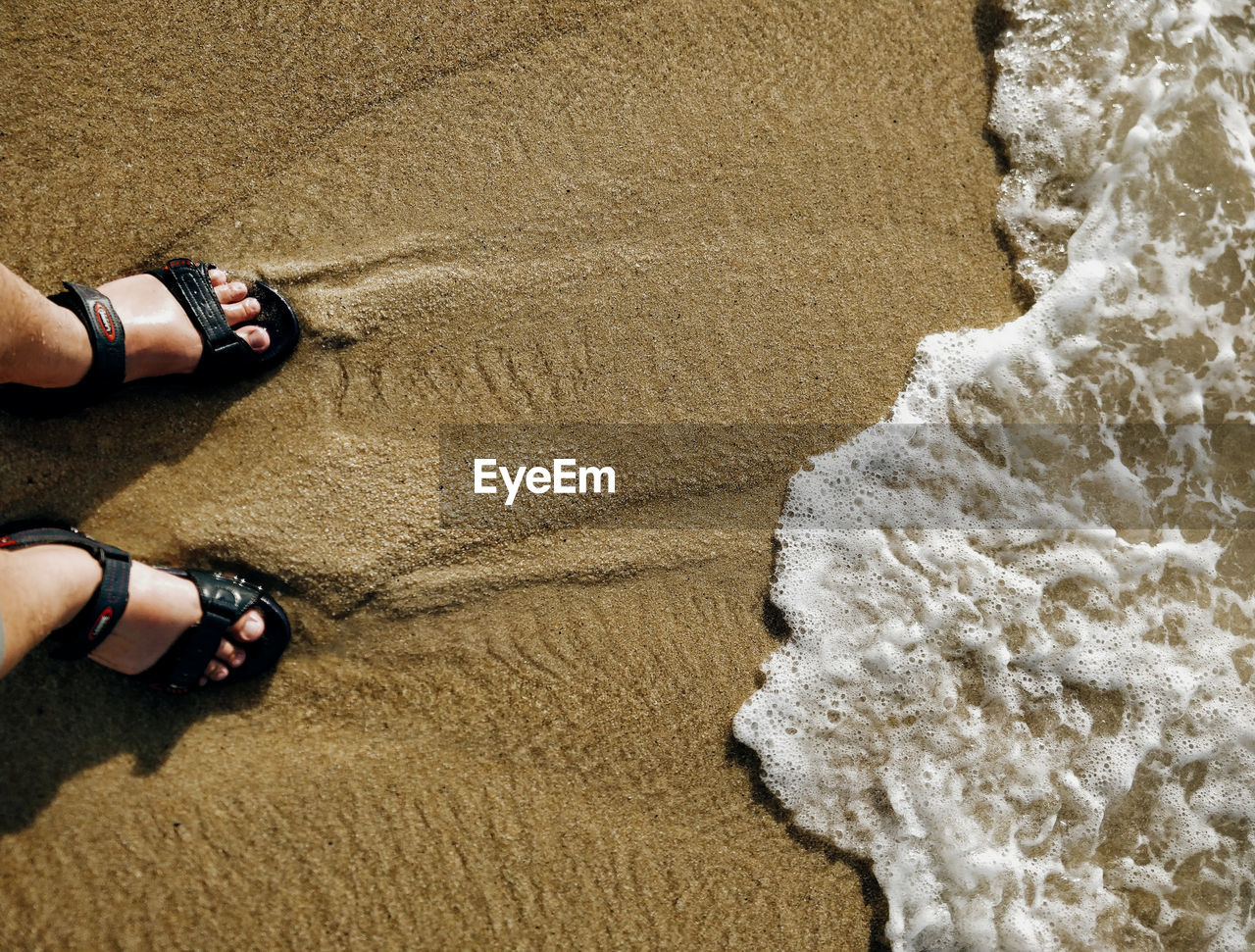 LOW SECTION OF SHOES ON SAND