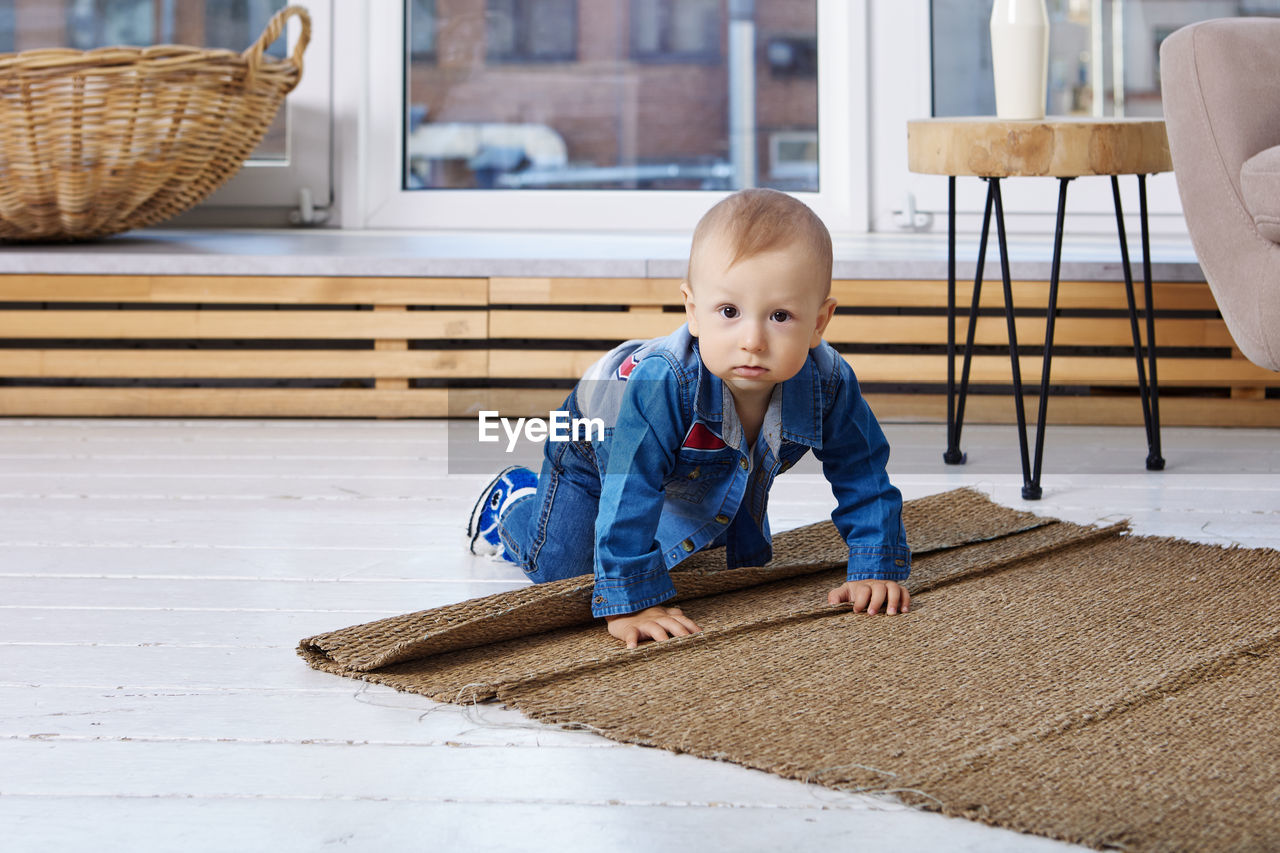 Full length of cute boy lying on floor