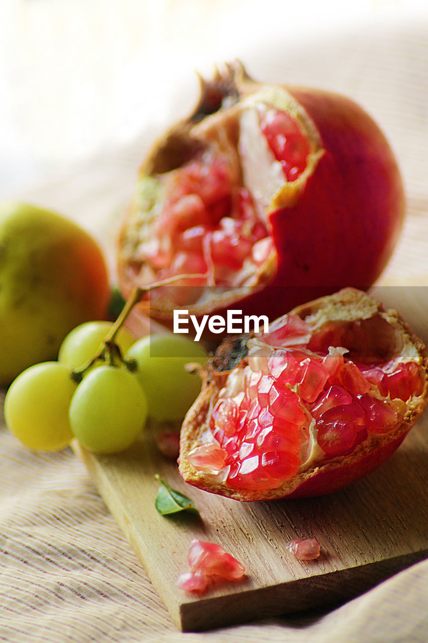 Close-up of pomegranate and grapes on cutting board