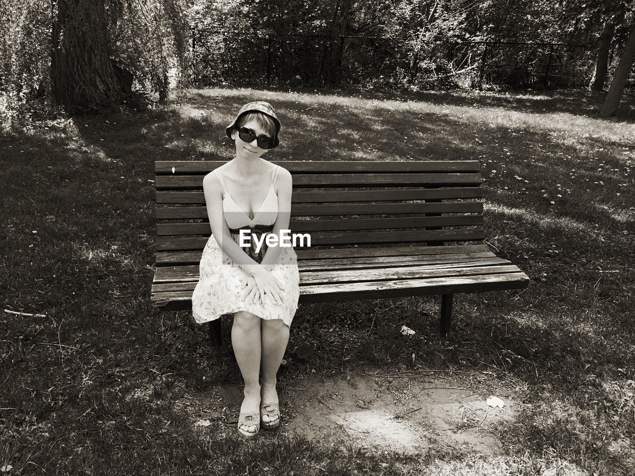 FULL LENGTH PORTRAIT OF WOMAN STANDING ON BENCH AGAINST PLANTS