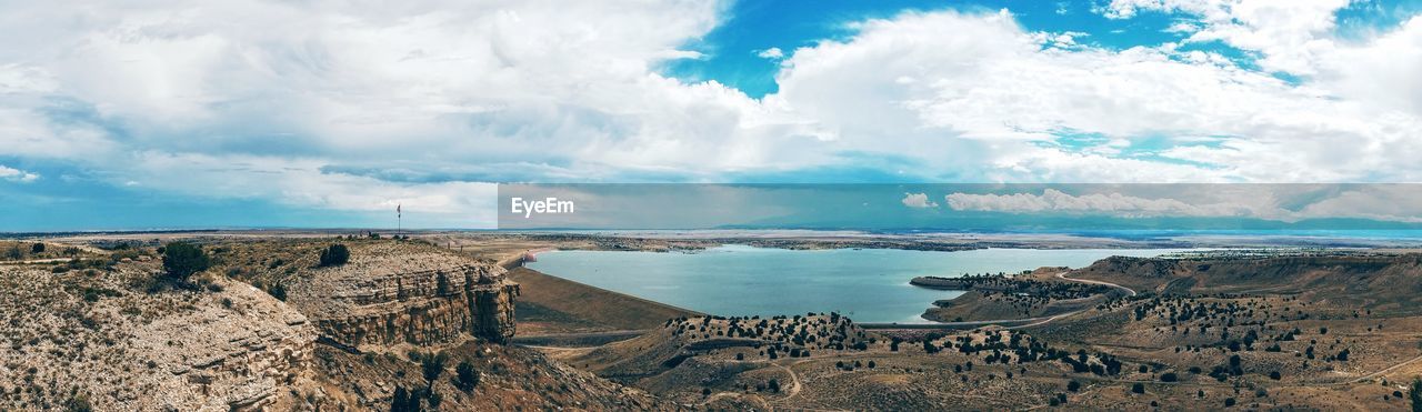 Scenic view of beach against cloudy sky