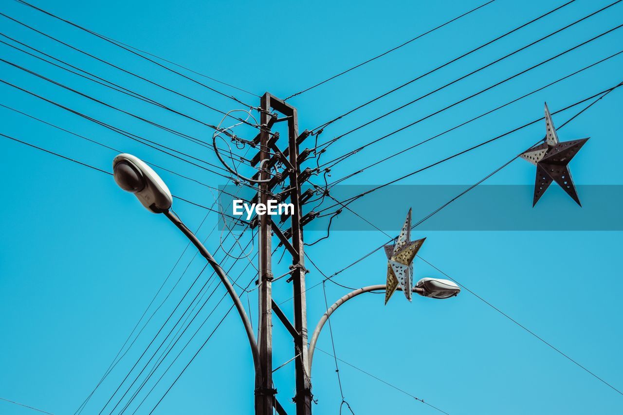 Low angle view of telephone line against clear blue sky