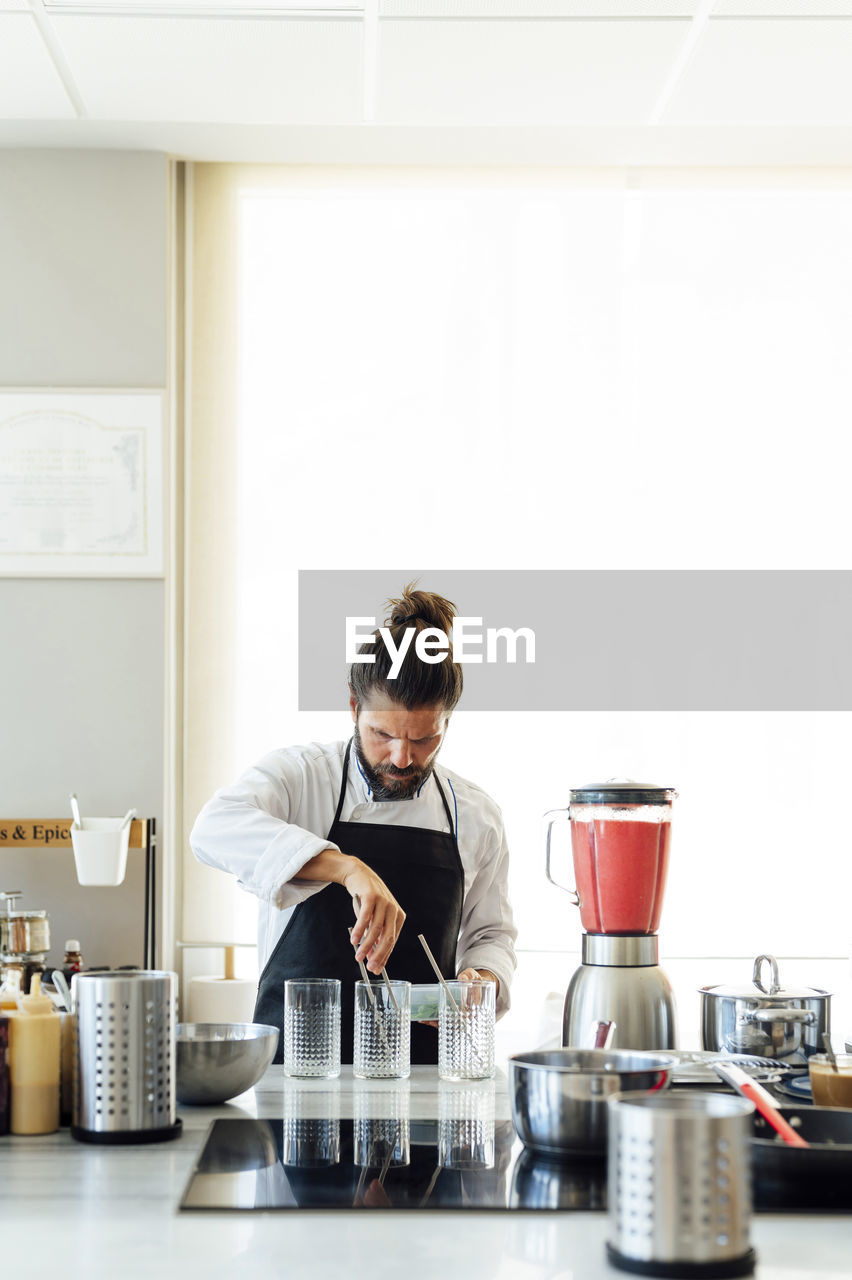 Mature male chef preparing smoothie in kitchen at restaurant