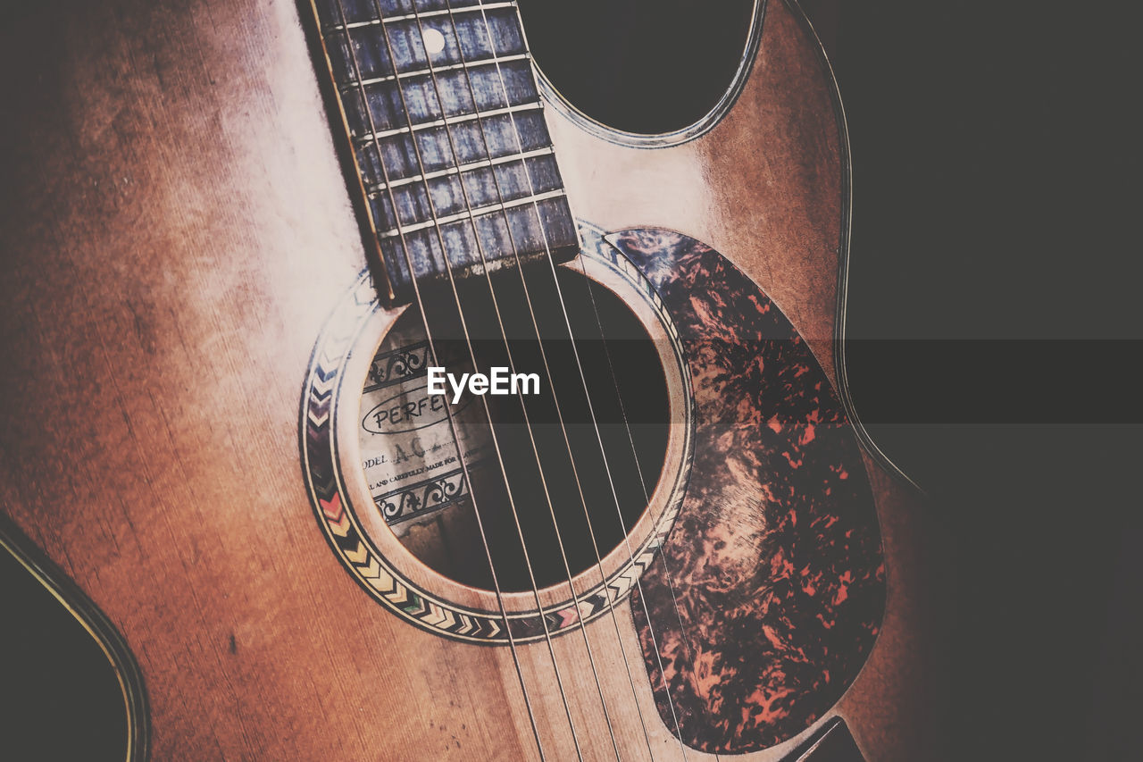 CLOSE-UP OF GUITAR IN THE DARK