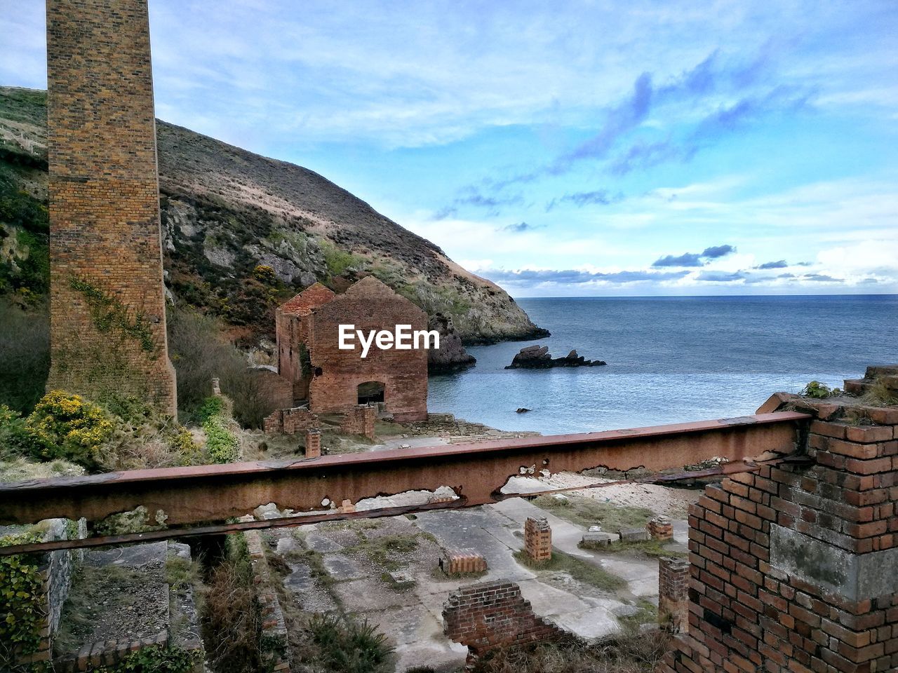 Close-up of built structure by sea against sky