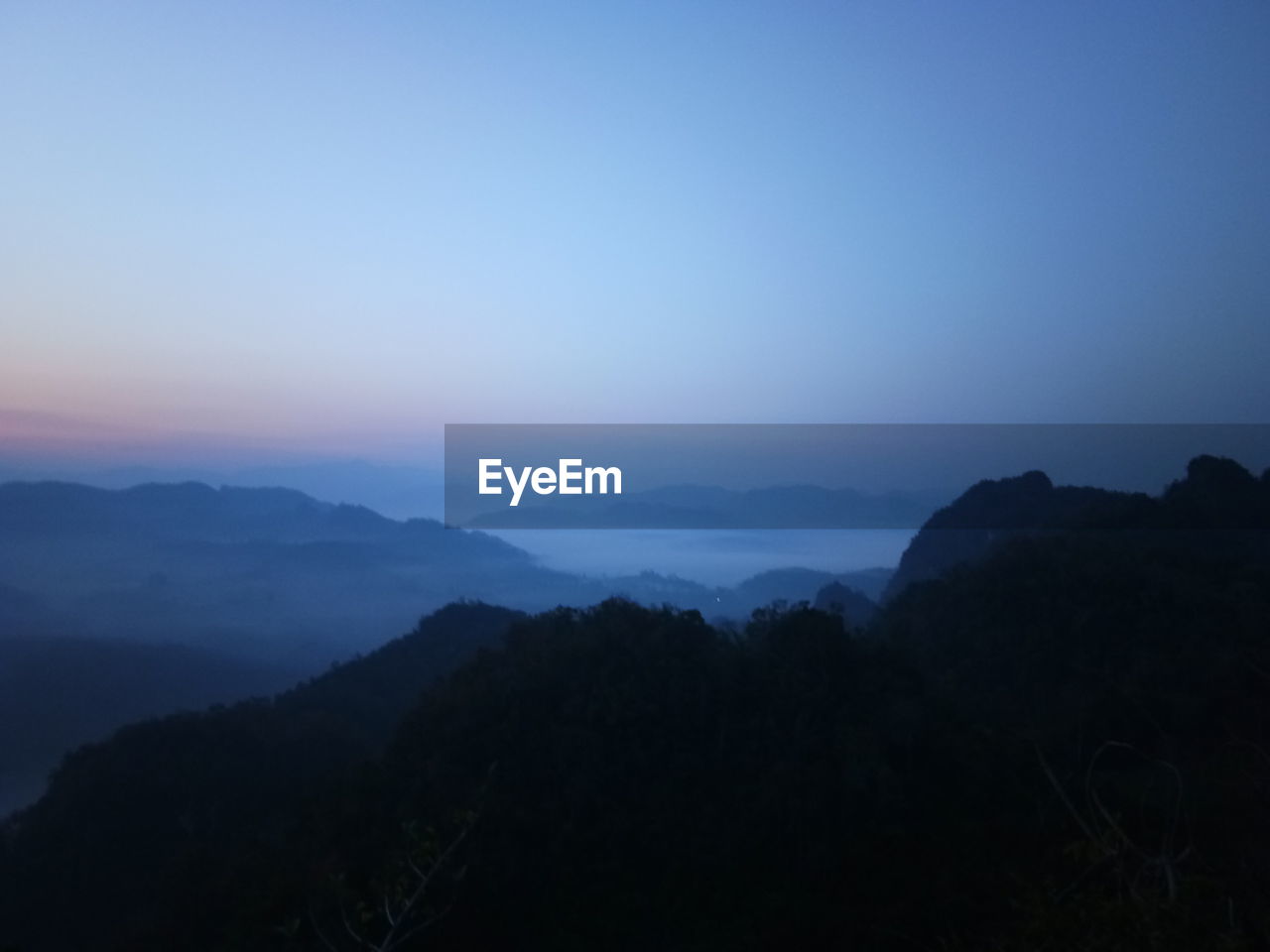 Scenic view of silhouette mountains against sky at sunset