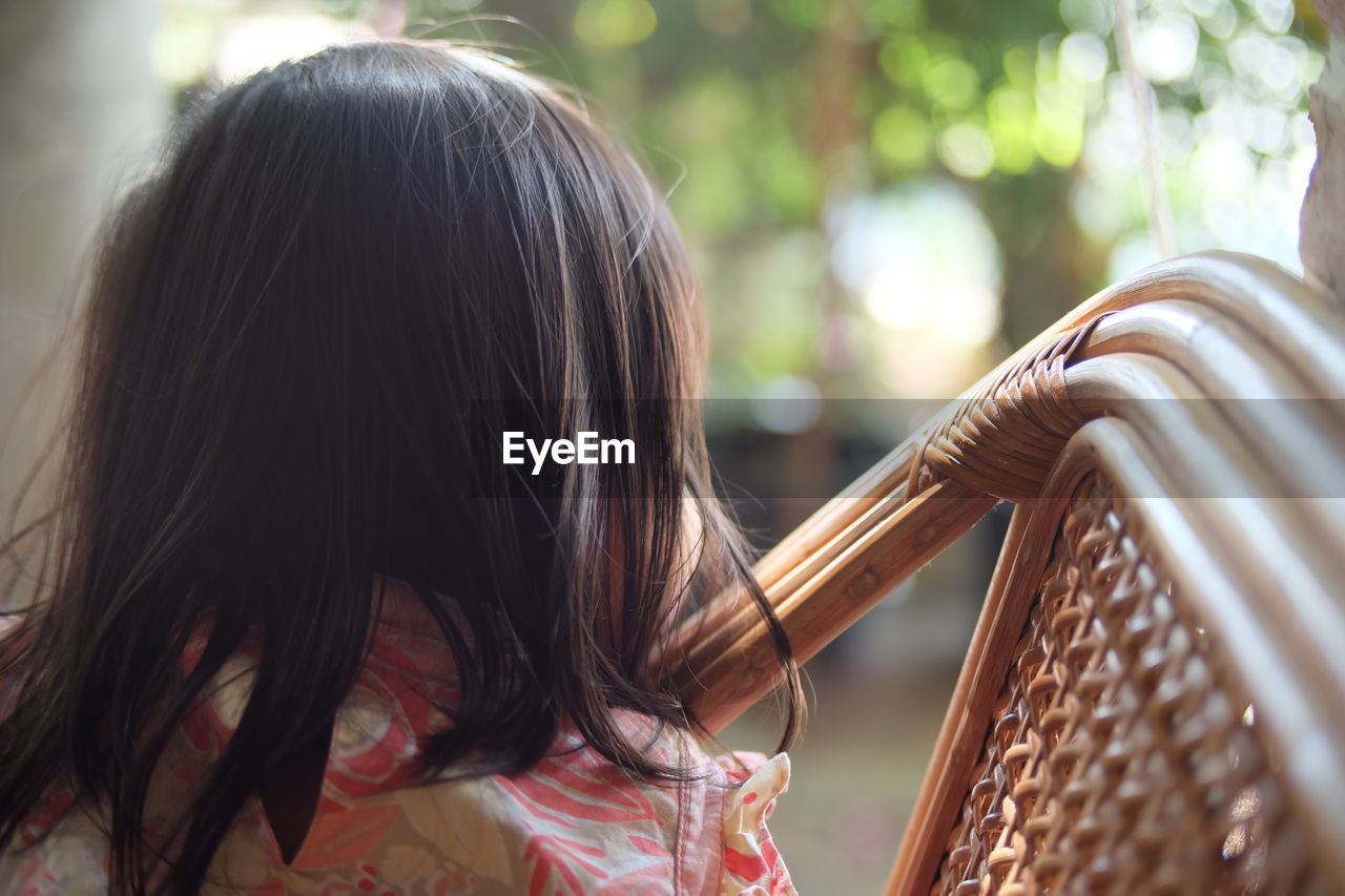 Rear view of girl sitting on chair