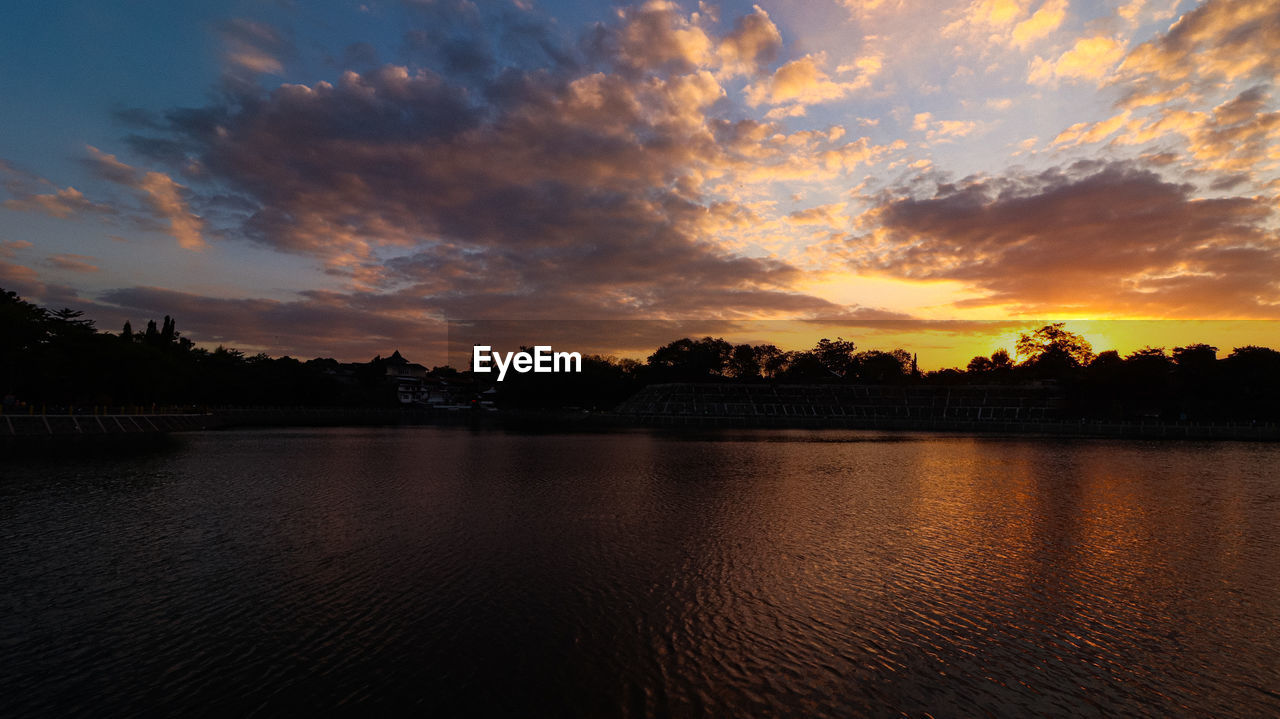 SILHOUETTE TREES BY LAKE AGAINST SKY DURING SUNSET