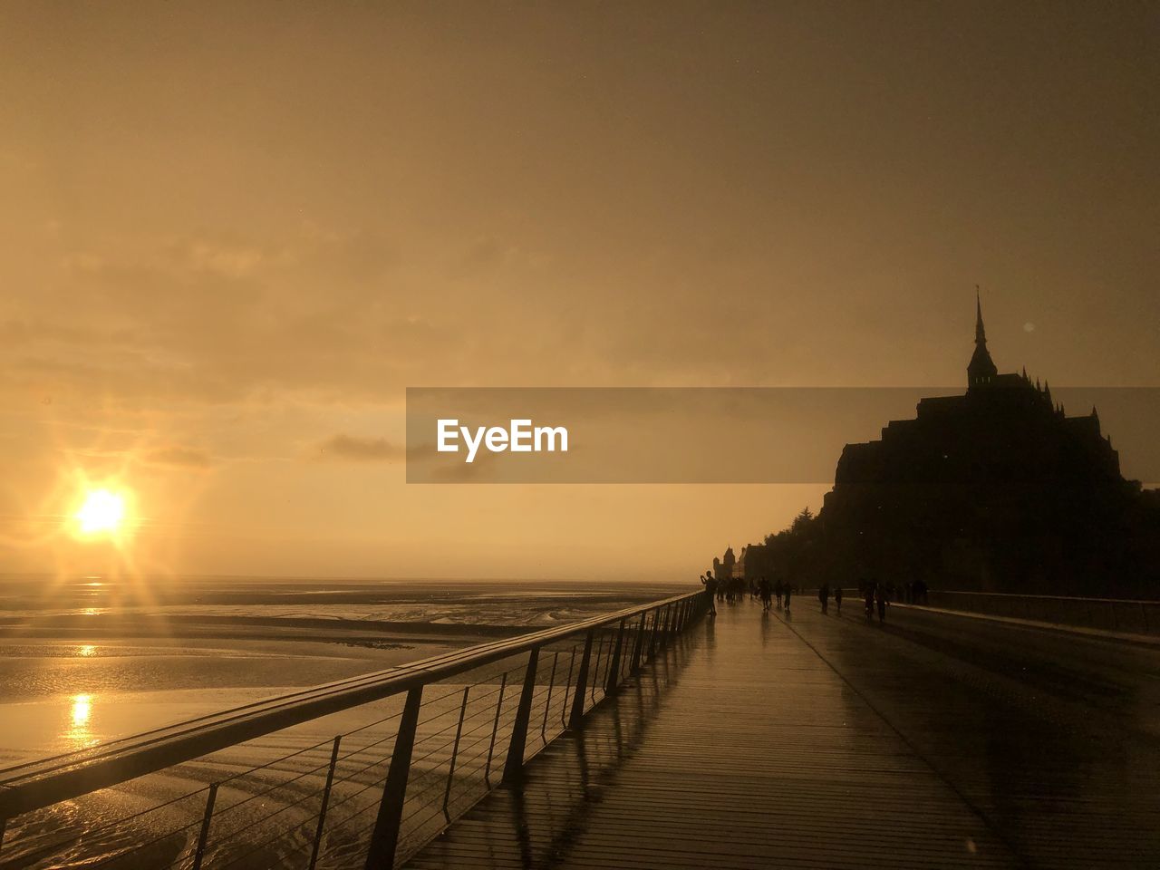 Mont saint-michel scenic view of sea against sky during sunset, after rain