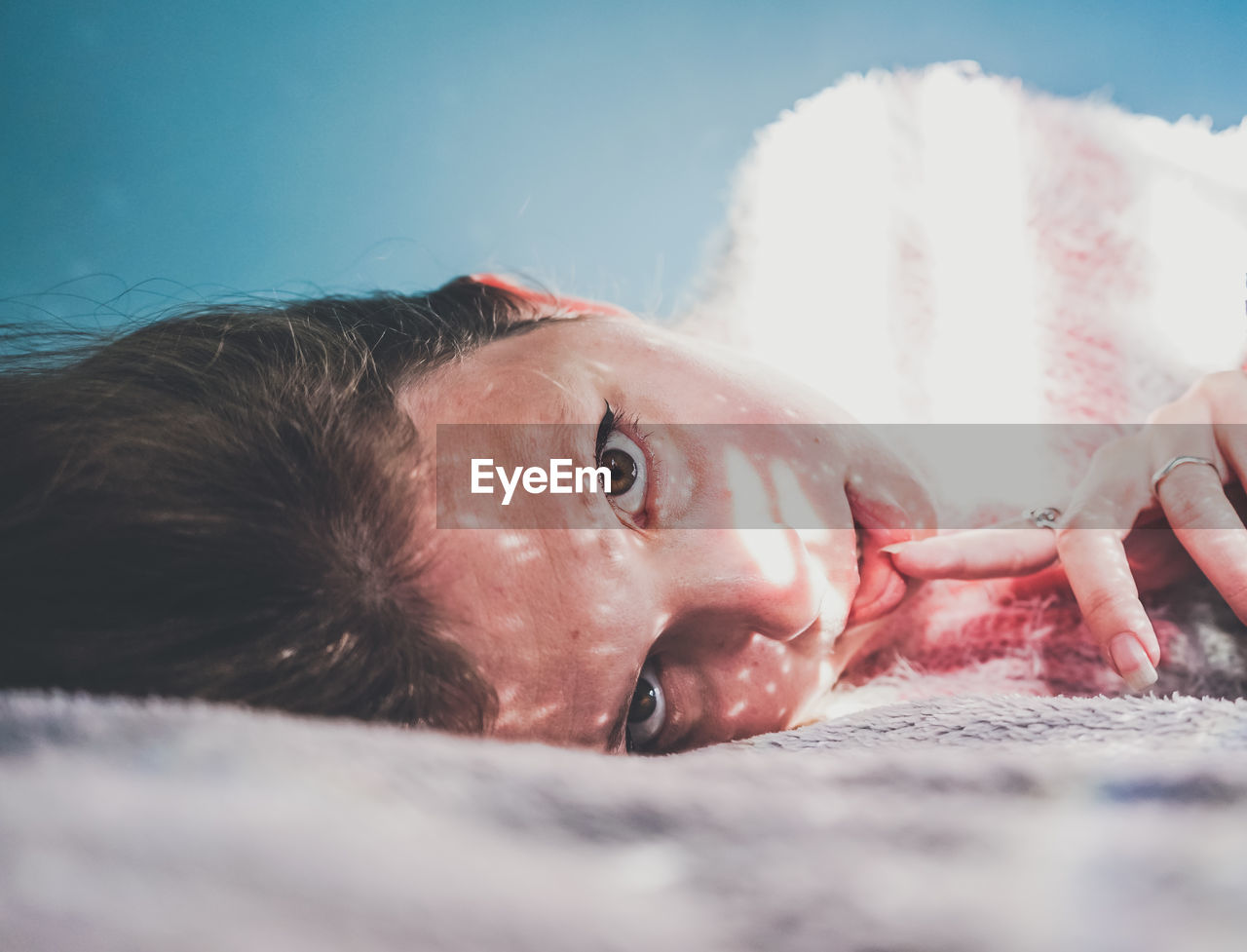 Portrait of woman lying on bed