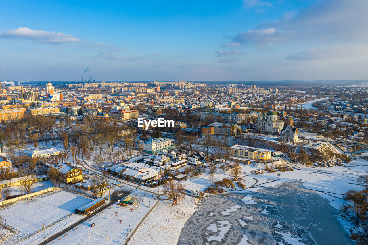 Nice top view of the winter city. houses and buildings in the snow. bridge over river. 