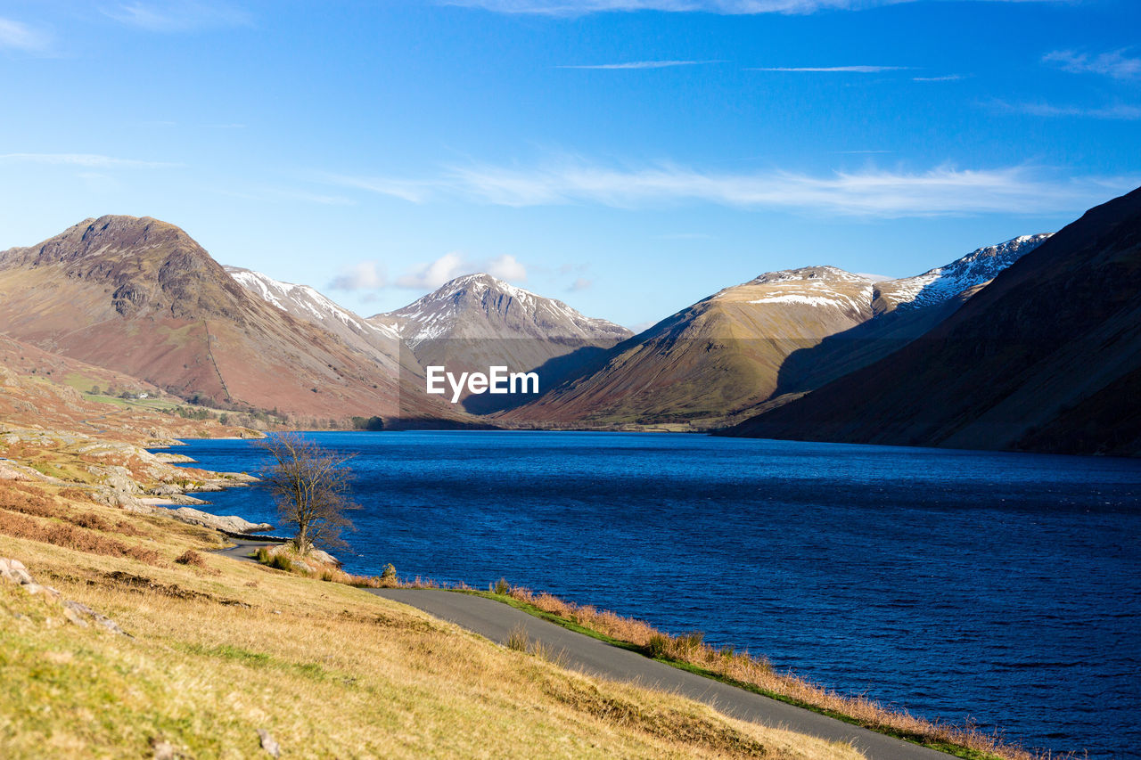 Scenic view of mountains against blue sky