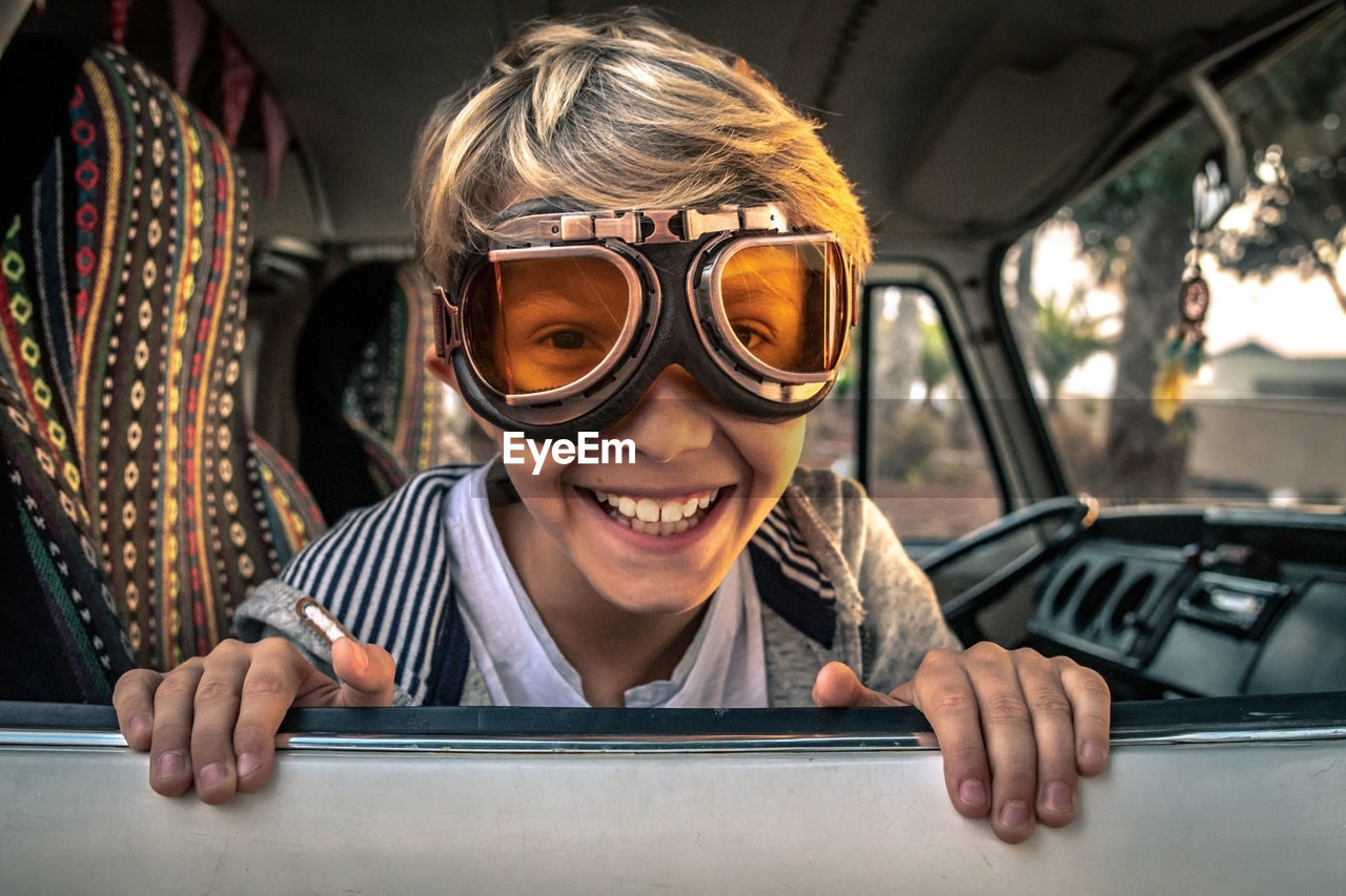 Portrait of happy boy wearing eyewear in car