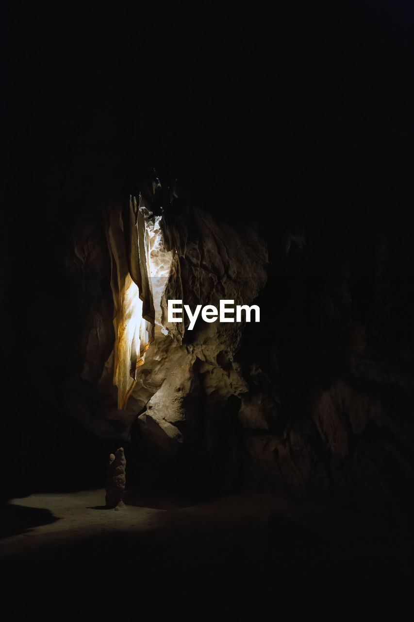 CLOSE-UP OF ILLUMINATED ROCK FORMATION AGAINST BLACK BACKGROUND