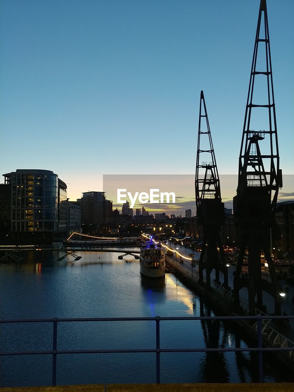 BRIDGE OVER RIVER AGAINST SKY DURING SUNSET