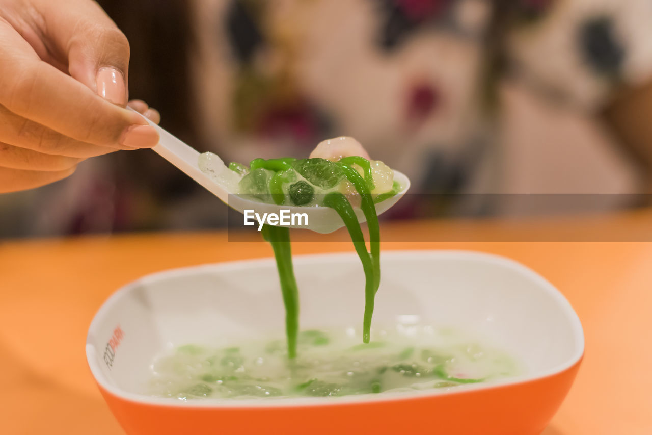 CLOSE-UP OF HAND HOLDING BOWL