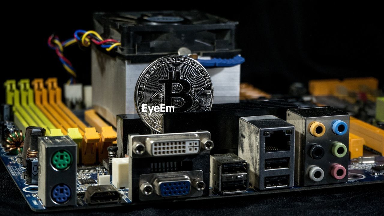 Close-up of bitcoin and machine part