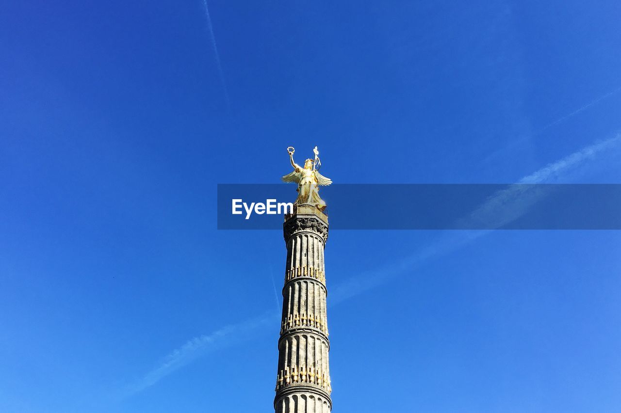 Low angle view of berlin victory tower against clear blue sky