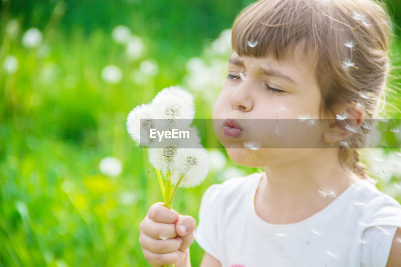 portrait of young woman holding dandelion