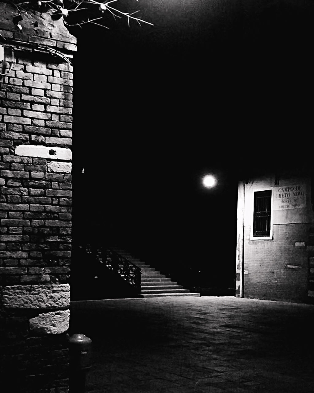 darkness, black, architecture, light, black and white, built structure, monochrome, night, white, monochrome photography, no people, building exterior, building, illuminated, wall - building feature, lighting equipment, wall, brick wall, brick, entrance, lighting, door, street light, street, outdoors, city