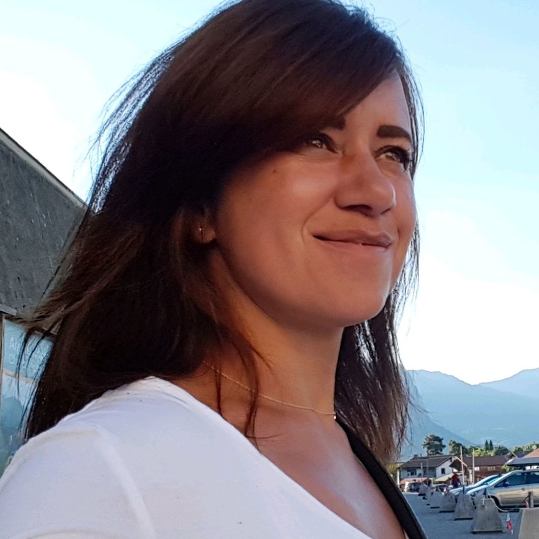 Close-up of smiling woman looking away against sky