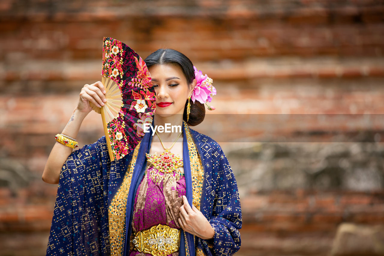 Woman in traditional clothing standing outdoors