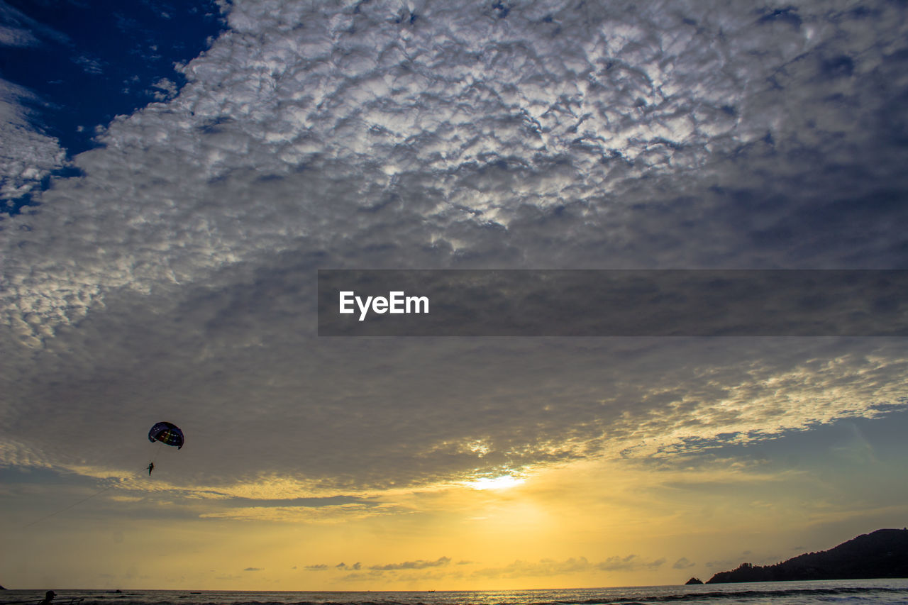 Scenic view of sea against cloudy sky during sunset