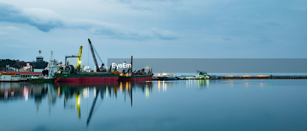 SAILBOATS IN COMMERCIAL DOCK AGAINST SKY