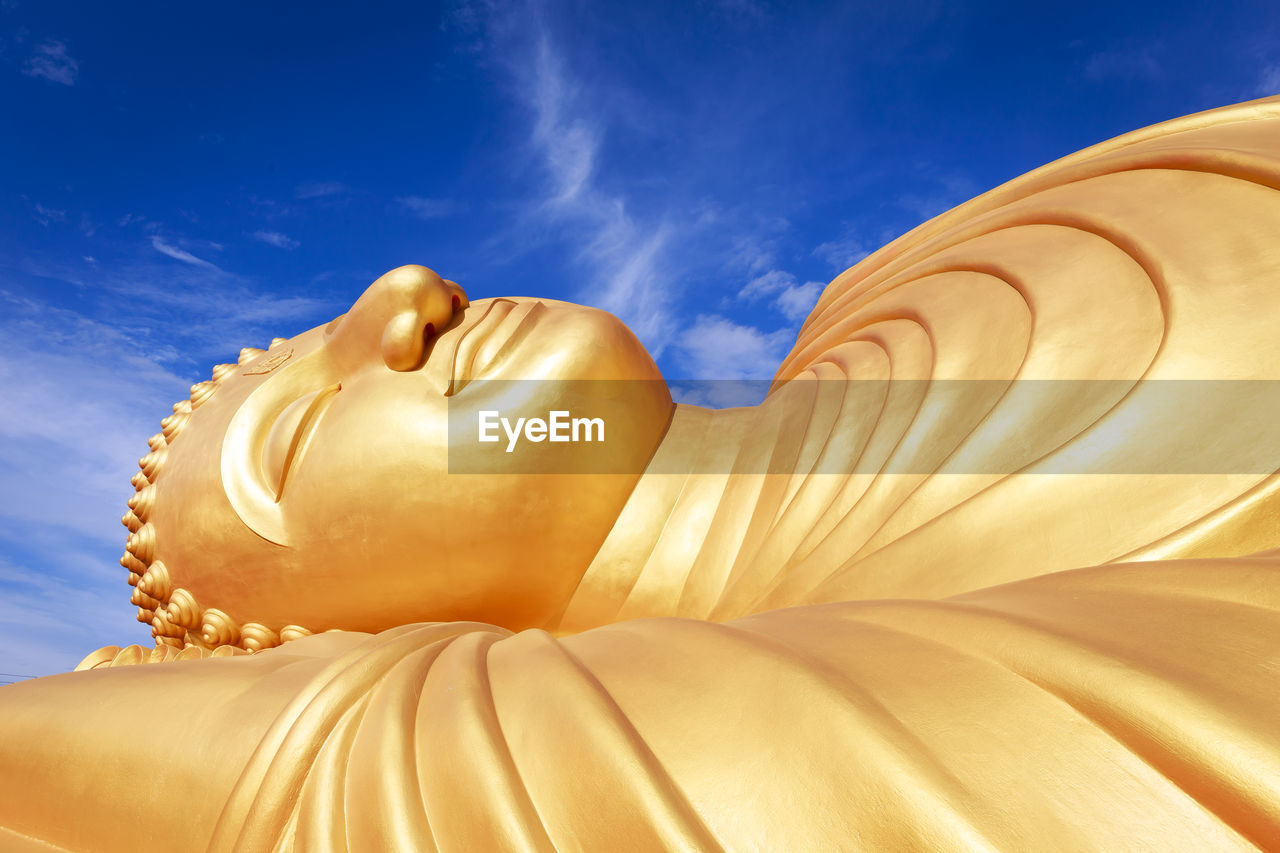 Close-up of buddha statue against sky