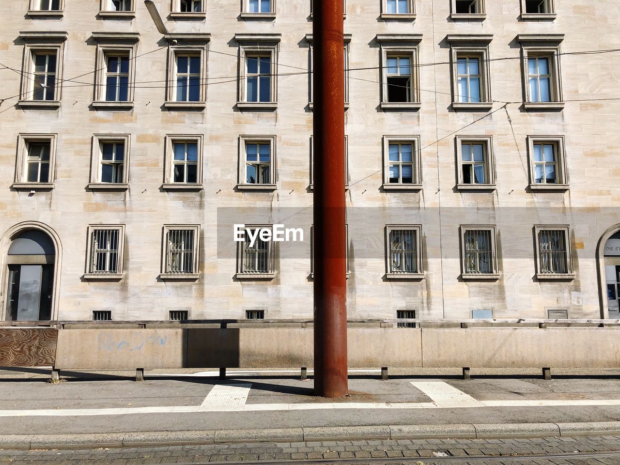 Red pole on sidewalk against building