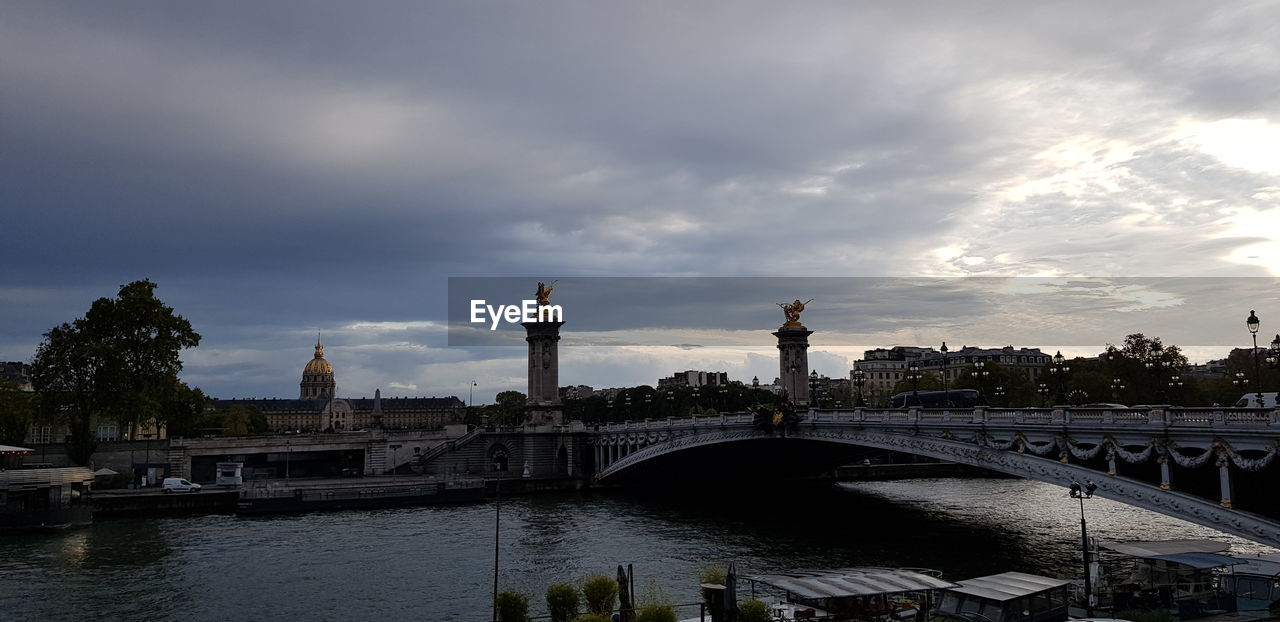 VIEW OF BRIDGE OVER RIVER AGAINST BUILDINGS