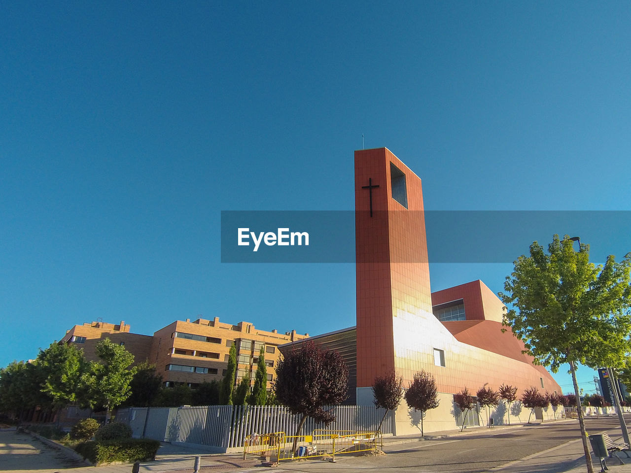 Outside view of a modern church with its high bell tower on a sunny afternooon with blue sky