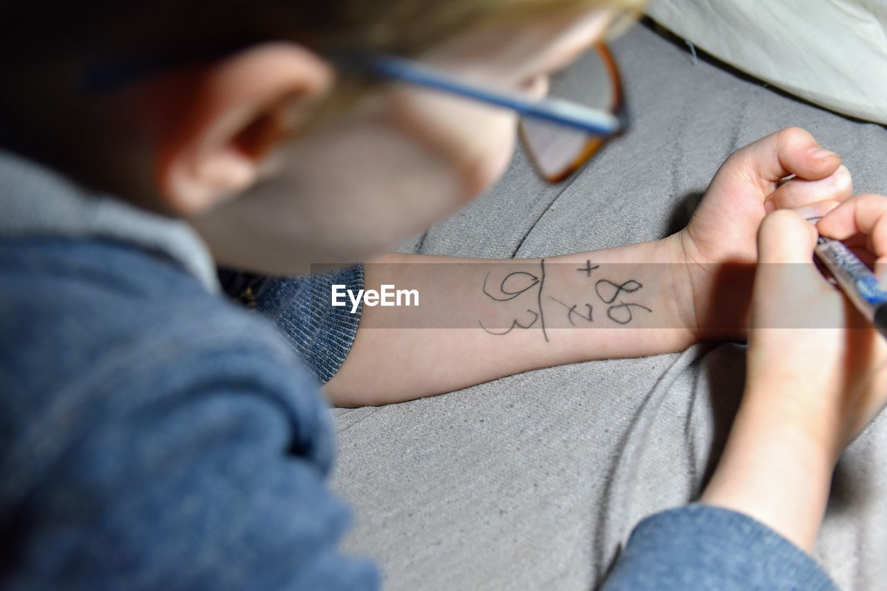 Close-up of boy writing on hand