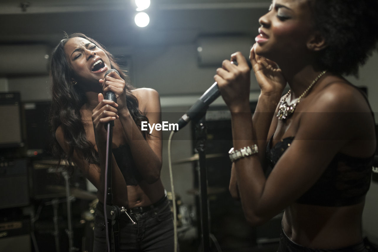 Young women singing in a recording studio