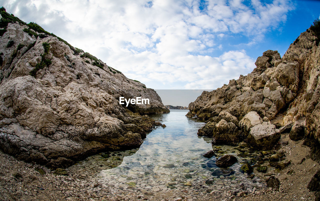 View of rocky beach against clouds