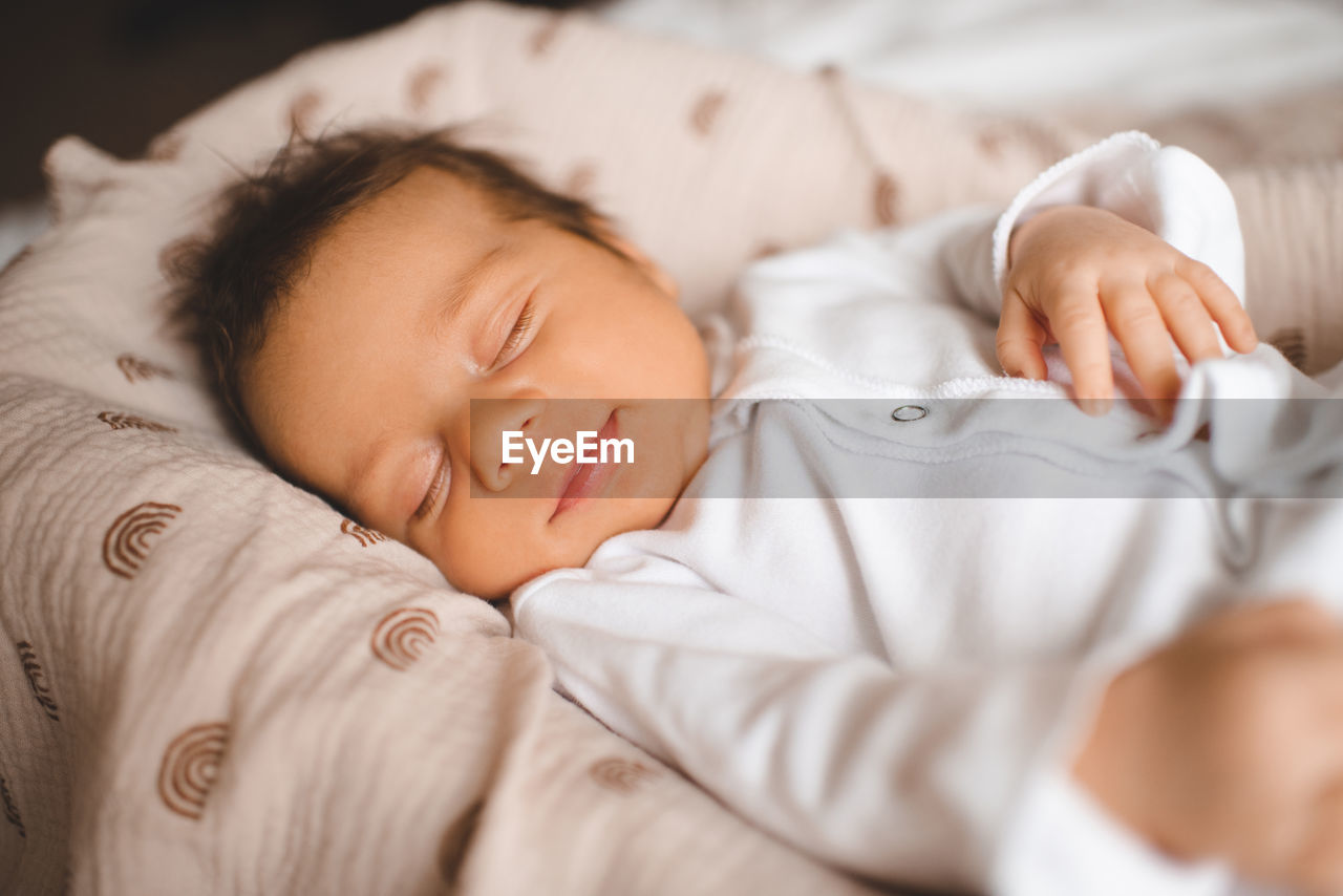 close-up of baby boy sleeping on bed at home