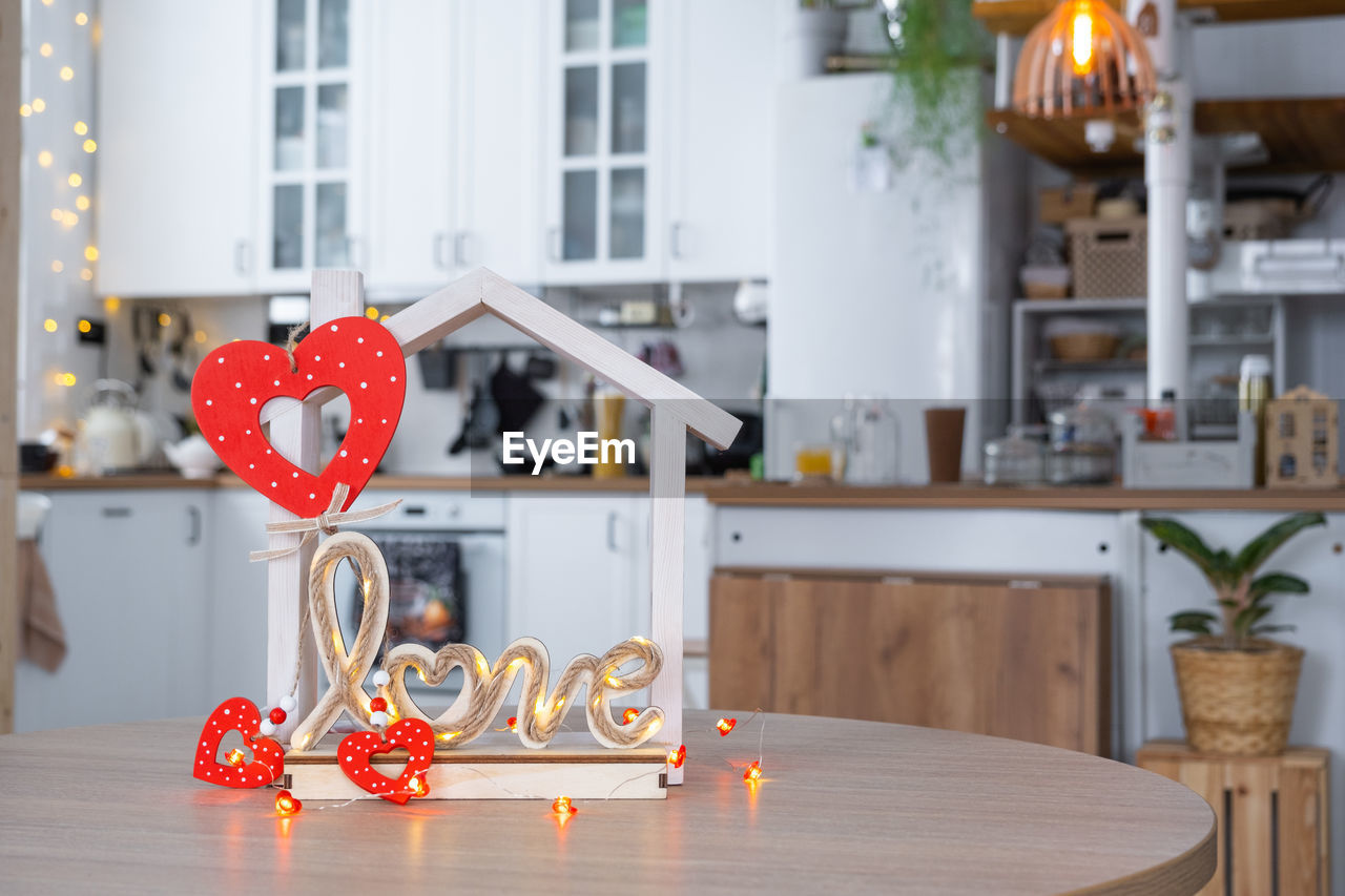 candle, table, home interior, indoors, decoration, no people, celebration, domestic life, lighting equipment, domestic room, focus on foreground, nature, furniture, window, home, food and drink, day, architecture, love, heart shape, wood, illuminated, lifestyles, vase