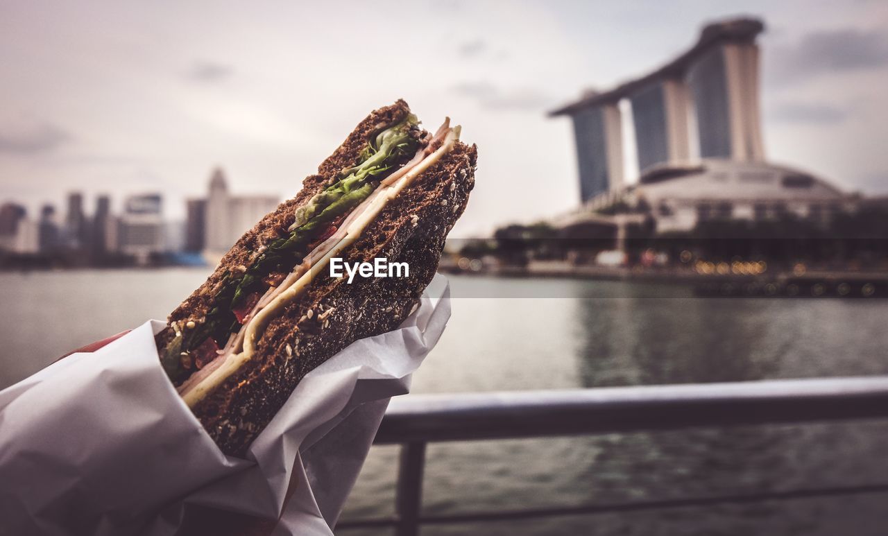 Close-up of sandwich by river in city