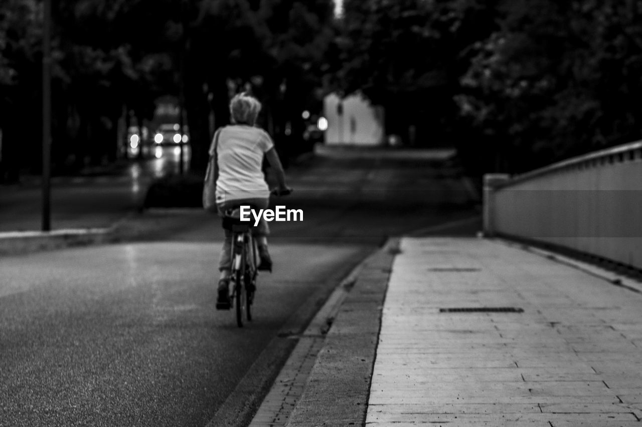 Rear view of boy riding bicycle