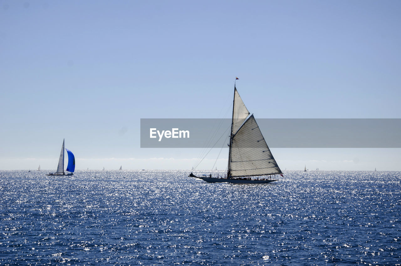 Sailboat in sea against clear sky