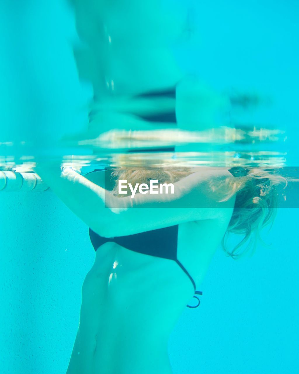 Midsection of young woman swimming in pool